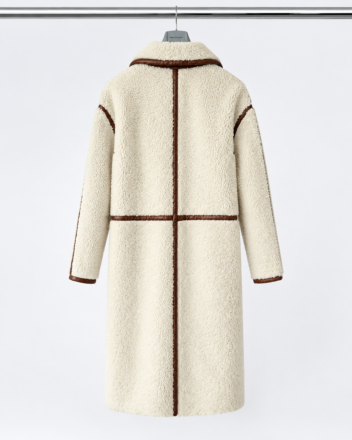 Belstaff Airstream Women’s Shearling Coat A cream-colored sherpa fleece coat with brown contrast trim, hanging on a hanger against a light gray background.