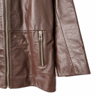 Close-up of a brown faux-leather jacket with a vertical zippered pocket and silver-tone zipper pulls, shown against a plain white background.
