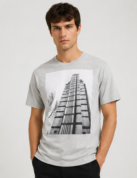 Dries Van Noten Grey Hertz Tower T-Shirt A man wearing a light gray heather crewneck t-shirt with a large black and white graphic print of a modernist building on the front, set against a plain light gray background.
