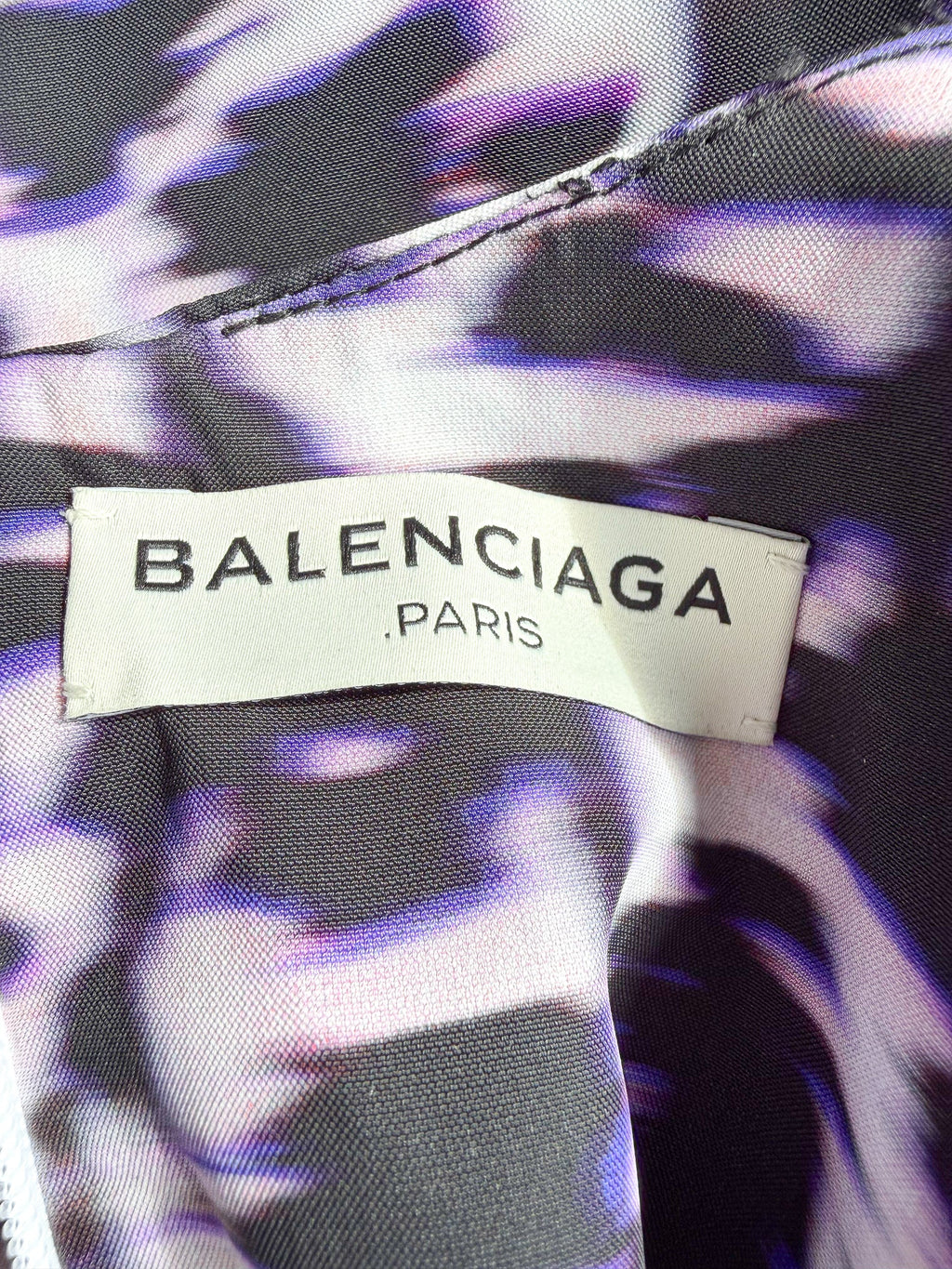 Balenciaga label on a garment with a purple and black patterned background