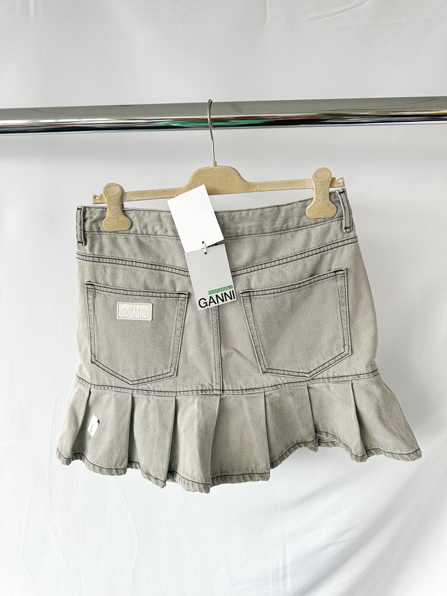 Mini-jupe Ganni grise preppy à ourlet plissé et patch logo