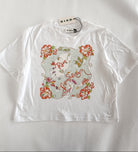 A white short-sleeve crop top t-shirt by RIXO, featuring a colorful graphic print on the front with red hibiscus flowers, green leaves, and a central illustration. The brand tag 'RIXO' is visible at the collar.