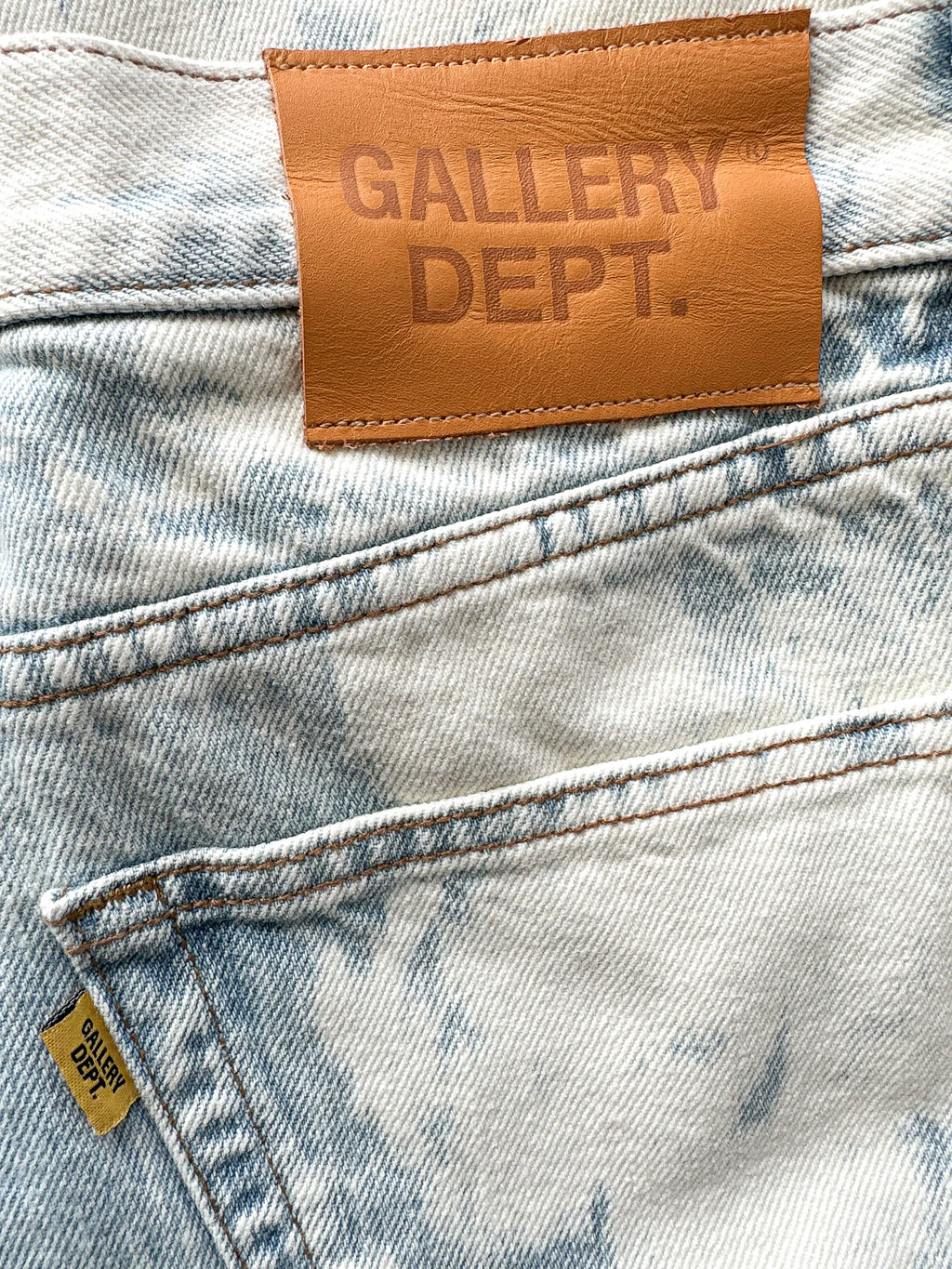 Close-up of a denim fabric with a 'GALLERY DEPT.' leather label.