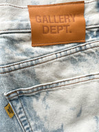 Close-up of a denim fabric with a 'GALLERY DEPT.' leather label.