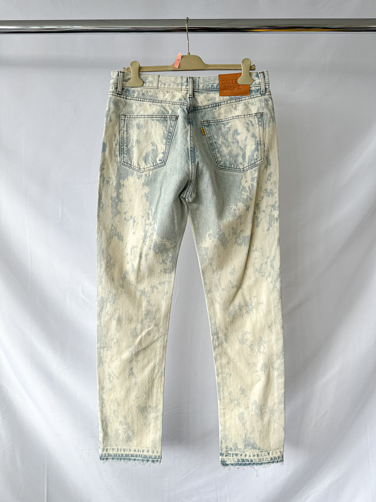 Gallery Dept Aged acid-wash jeans on a hanger against a plain background