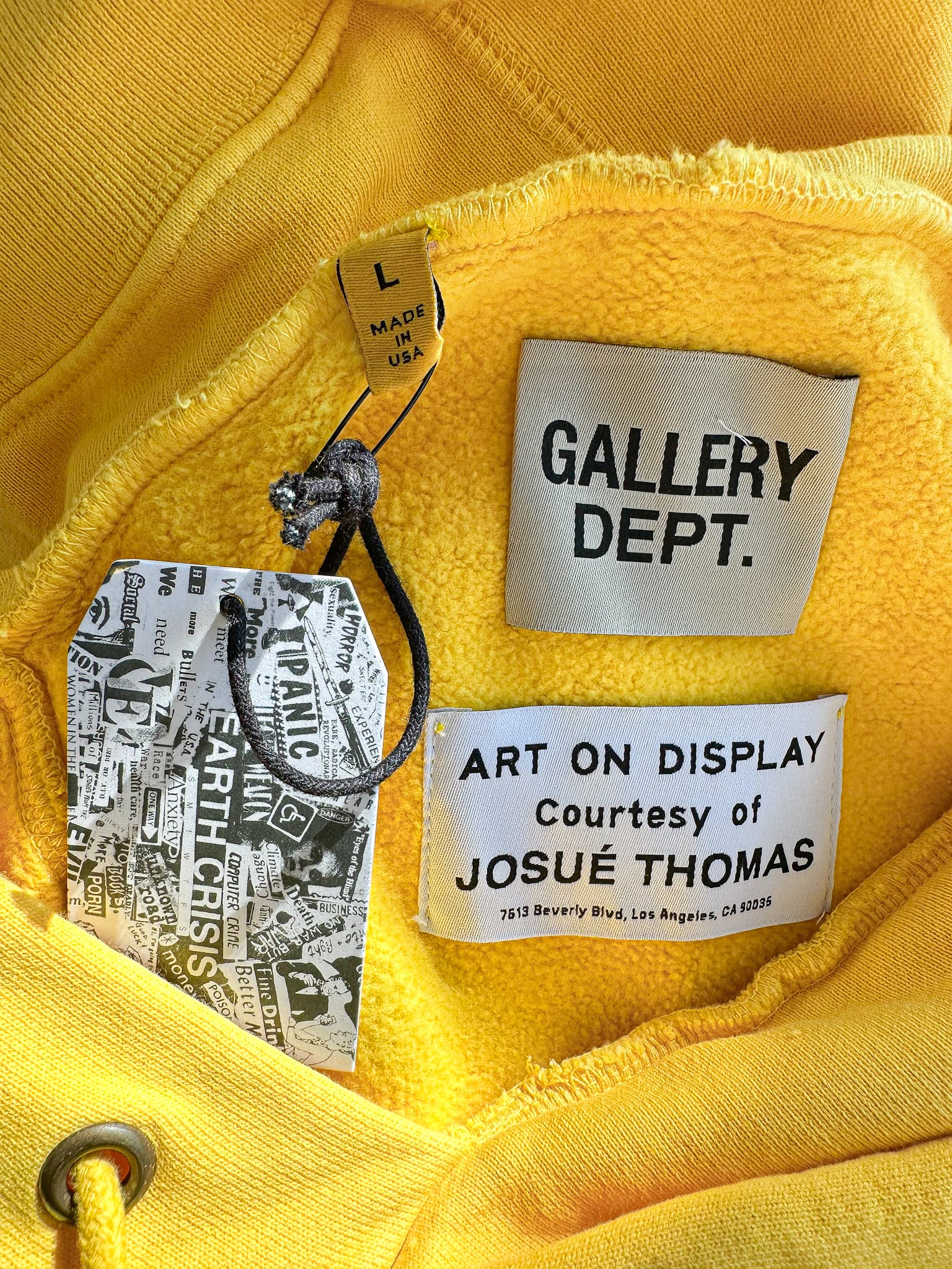 Close-up of a yellow garment with 'Gallery Dept.' and 'José Thomas' labels.