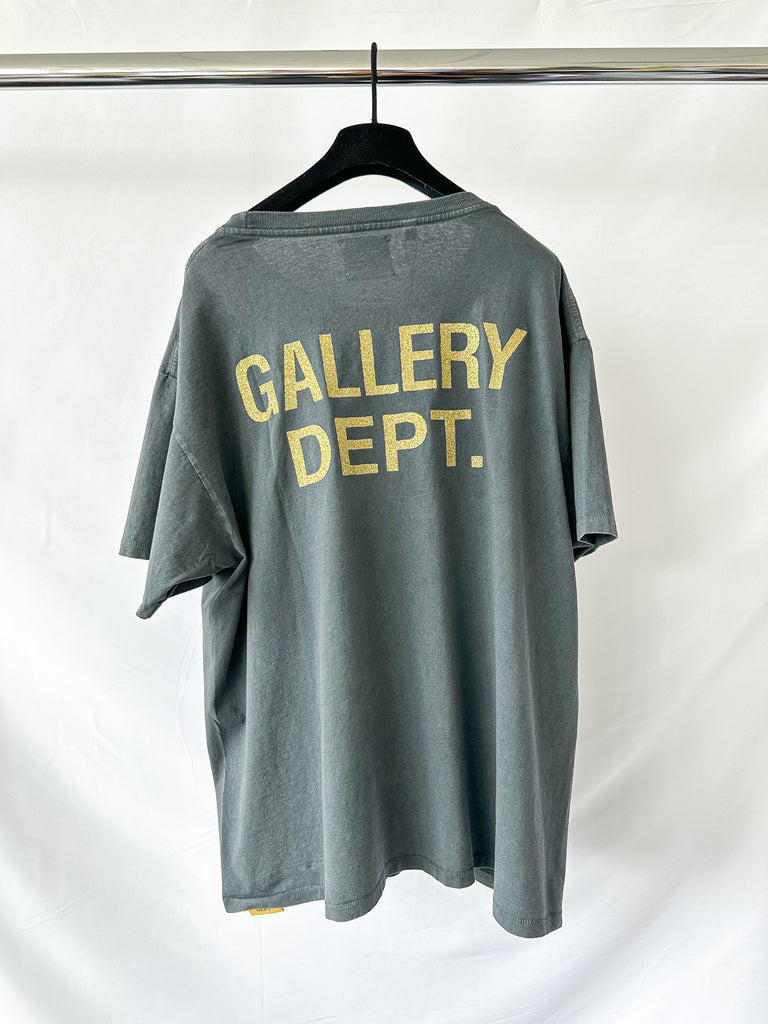 Gray t-shirt with 'GALLERY DEPT.' text on a hanger against a white background