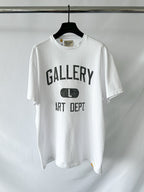 White t-shirt with 'GALLERY ART DEPT' text on a hanger against a white background