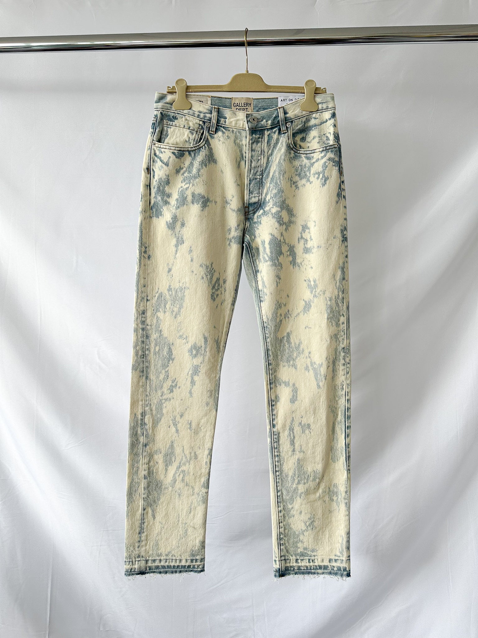 Gallery Dept Levi 501 Surf Distressed jeans on a hanger against a white background