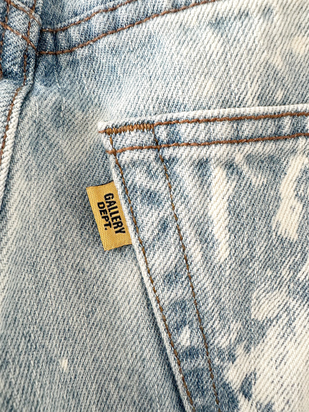 Close-up of a denim pocket with a 'GALLERY DEPT.' label.