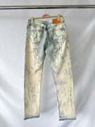 Gallery Dept Levi 501 idstressed white jeans on a hanger against a white background