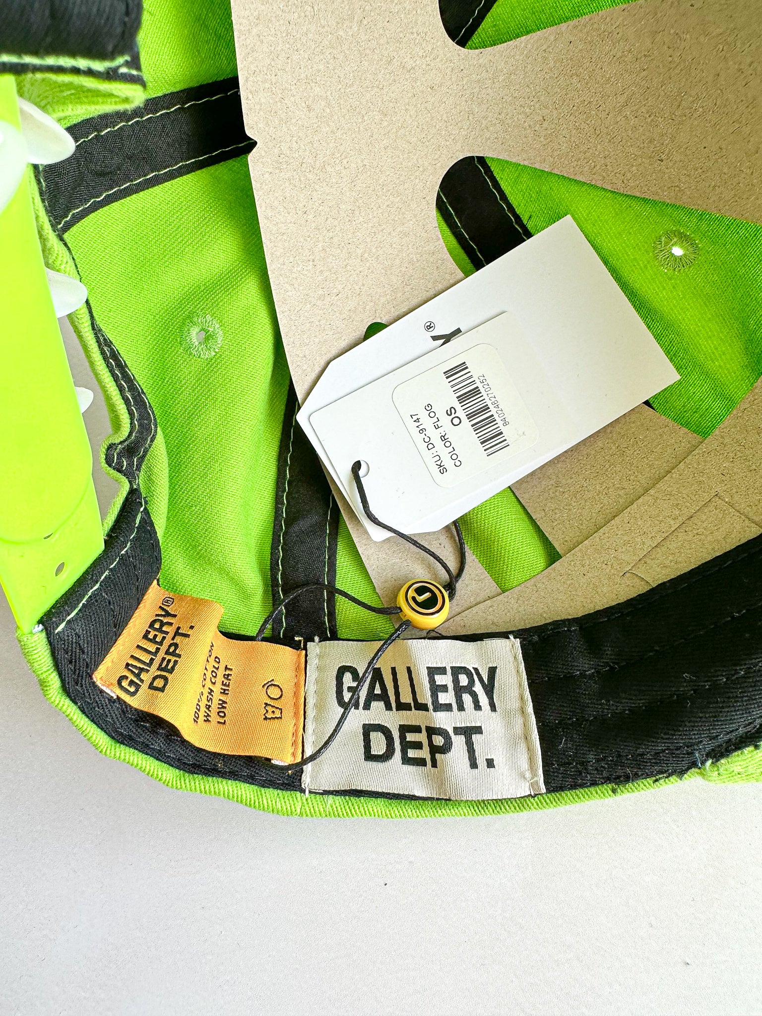 Green cap with 'Gallery Dept.' branding and a tag on a white background