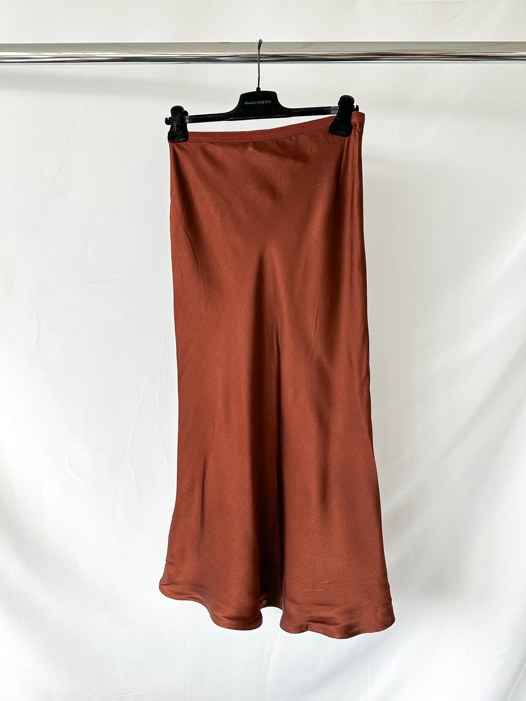 Brown skirt on a hanger against a white background