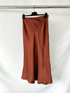 Brown skirt on a hanger against a white background