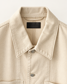 Close-up of a Lemaire Cream Workwear Over Shirt Denim Jacket with a pointed collar, silver metal buttons, and a black 'LEMAIRE' brand label inside the collar.