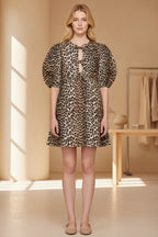 Model wearing a leopard print dress with puff sleeves against a neutral background