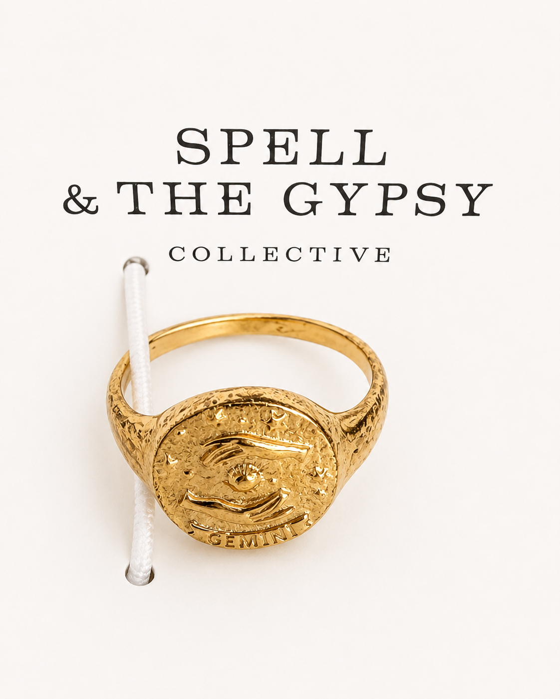 A textured gold signet ring with an eye of providence design and the zodiac sign Gemini, displayed on a white background with the brand name 'SPELL & THE GYPSY COLLECTIVE' printed above.